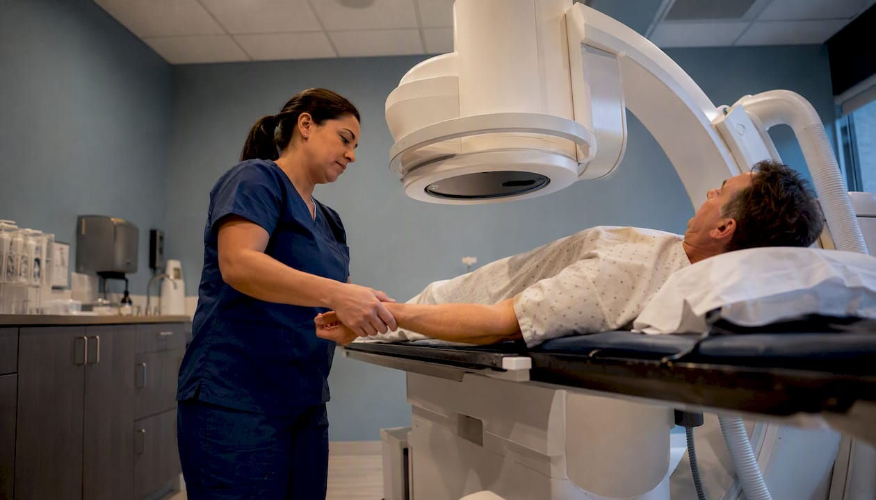 Patient undergoing fluoroscopy exam with technologist